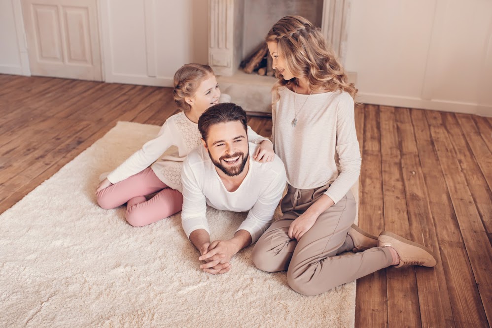 Happy young family with one child spending time together at home