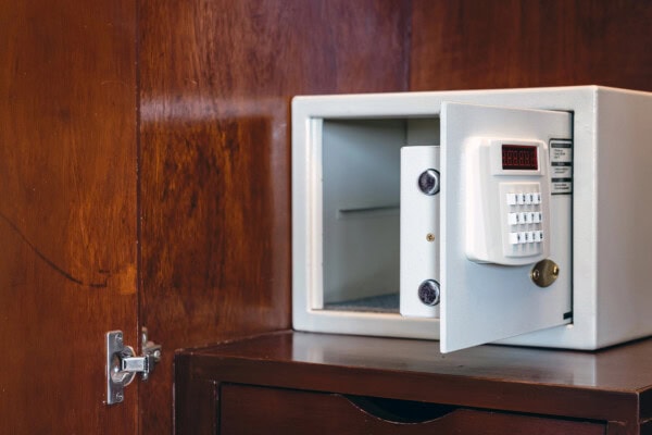 Security open metal safe with empty space inside in a wooden shelf.